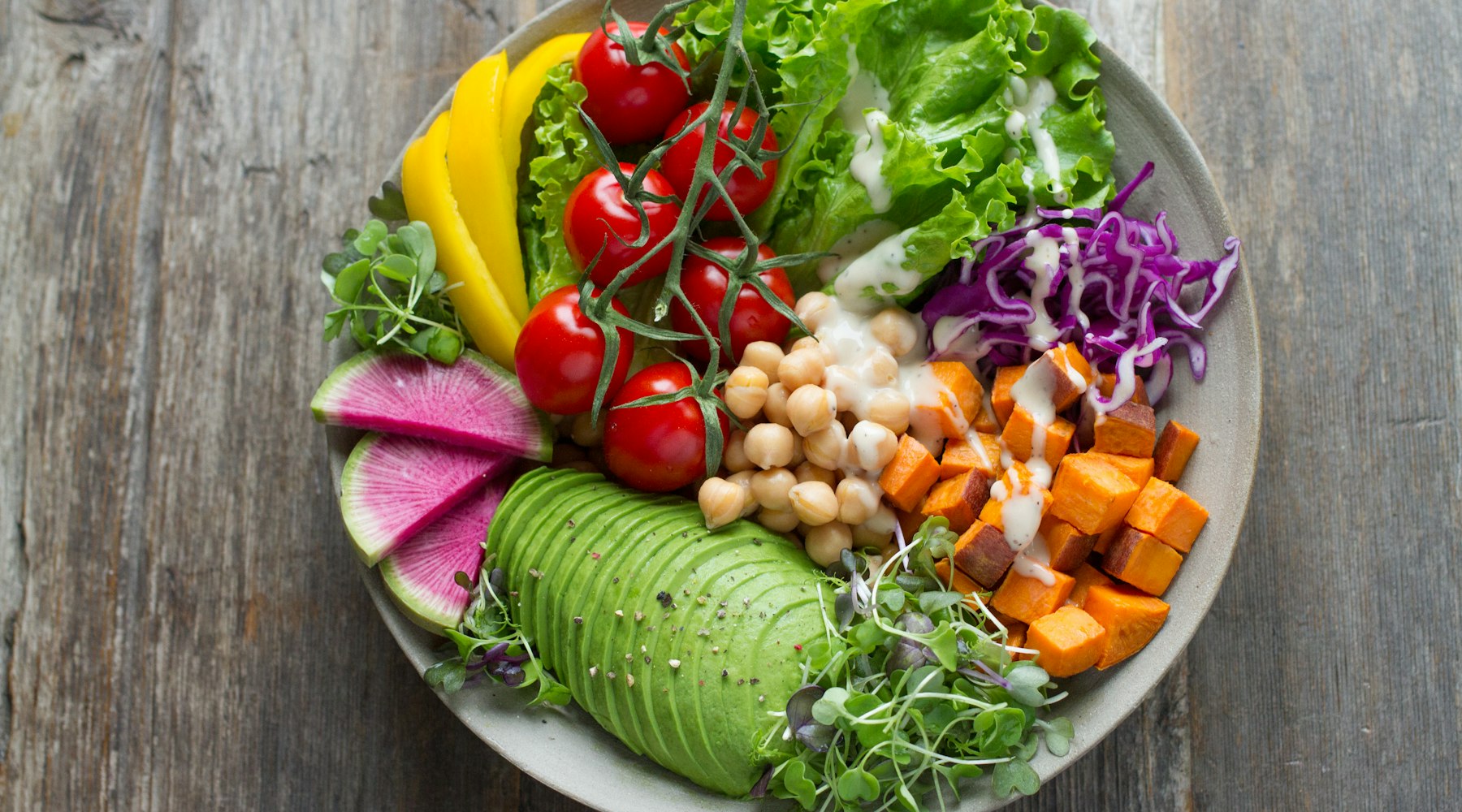 Colorful bowl of anti-inflammatory foods including blueberries, leafy greens, salmon, and turmeric for runner recovery