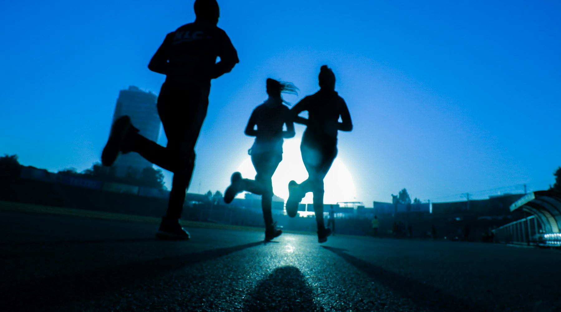 Runner performing high-intensity interval training on a track to improve VO2 max and endurance performance