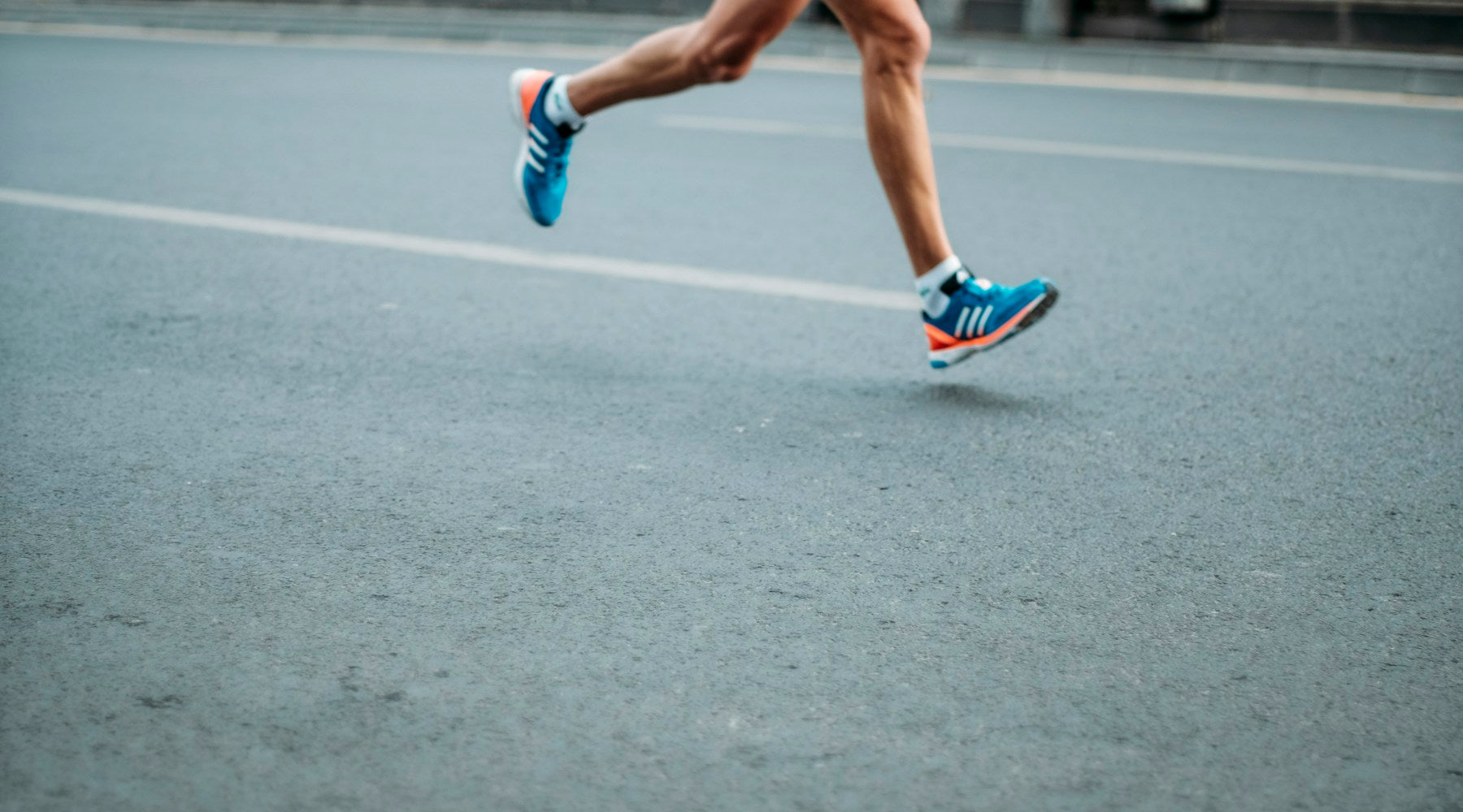 Runner sitting and recovering after completing a marathon race, holding their leg